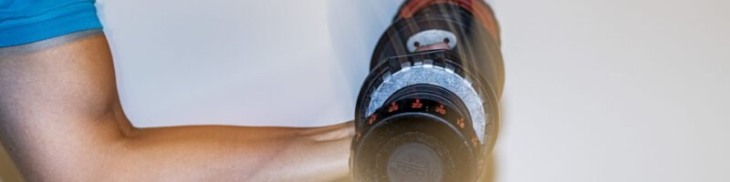 Patiënt voert een gecontroleerde armbeweging uit met een dumbbell tijdens fysiotherapeutische oefentherapie