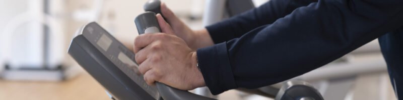 Persoon die een fitnessapparaat gebruikt tijdens oefentherapie of revalidatie in de praktijk