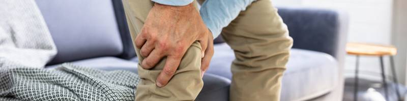 revalideren na knieoperatie Persoon houdt de knie vast als teken van knieklachten