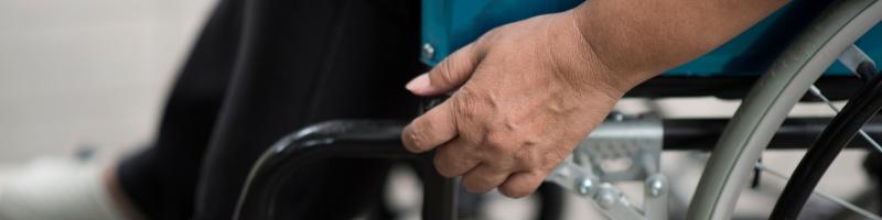 Multiple Sclerose Hand van een persoon op de armleuning van een rolstoel