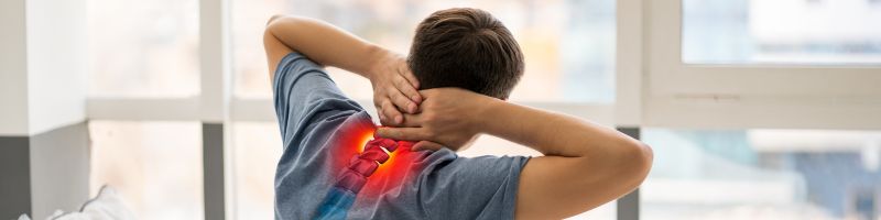 Nekhernia behandelen bij Rugcentrum Parkstad Persoon die met beide handen de nek vasthoudt, met een visuele aanduiding van een nekhernia